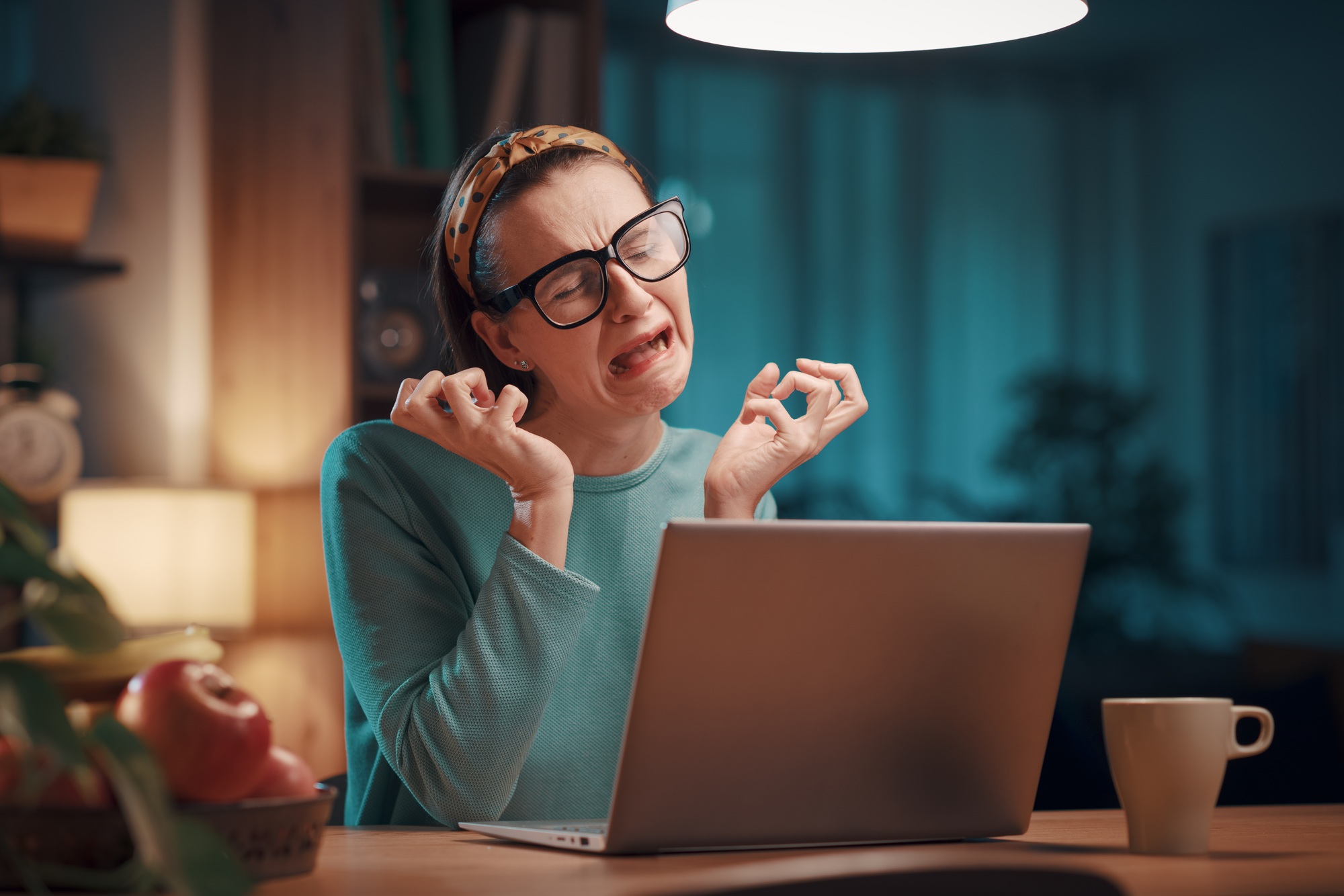 Woman crying and staring at her broken laptop